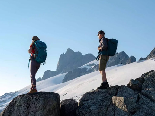 Hikers surrounded by snow-capped mountains and alpine lakes high above Whistler.