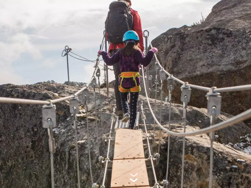 Guests crossing a suspended alpine feature during a guided Sky Walk on Whistler Mountain.