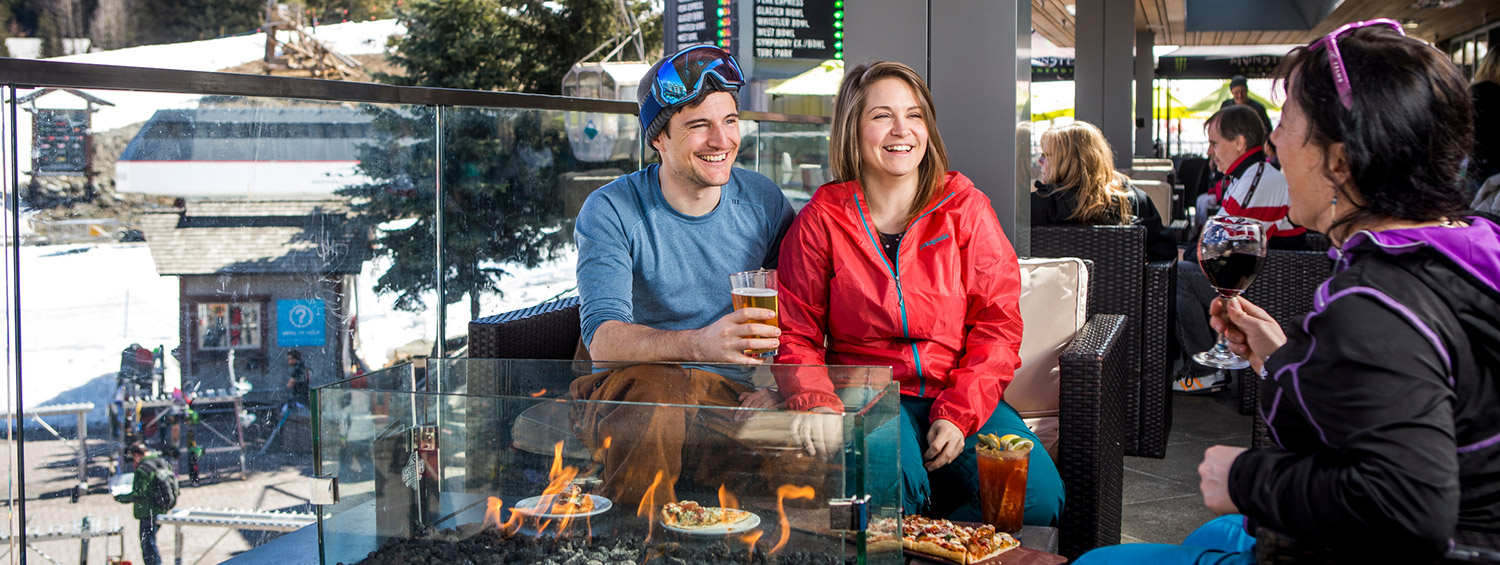 Three people enjoying spring apres on the patio at GLC