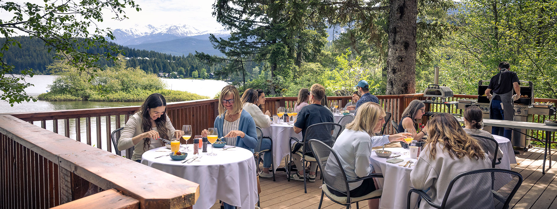 People enjoying dining outdoors at a lakeside Nourish Whistler Wellness Series event in spring