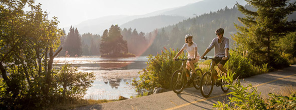 Two people on bikes enjoying August Long Weekend in Whistler