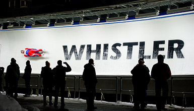 Spectators watching luger on track during World Cup at Whistler Sliding Centre