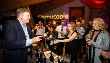 Guest savouring wine at Cornucopia's CRUSH tasting event in Whistler — an intimate moment of flavour, atmosphere and connection.