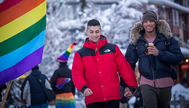 Pride participants celebrating on the slopes of Whistler with rainbow flags
