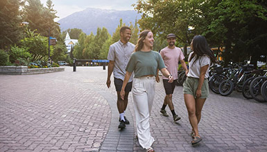 People walking through the pedestrian-only Whistler Village on a sunny summer day