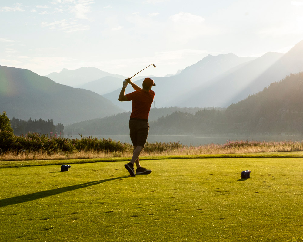Golfer teeing off at Nicklaus North Golf Course in Whistler
