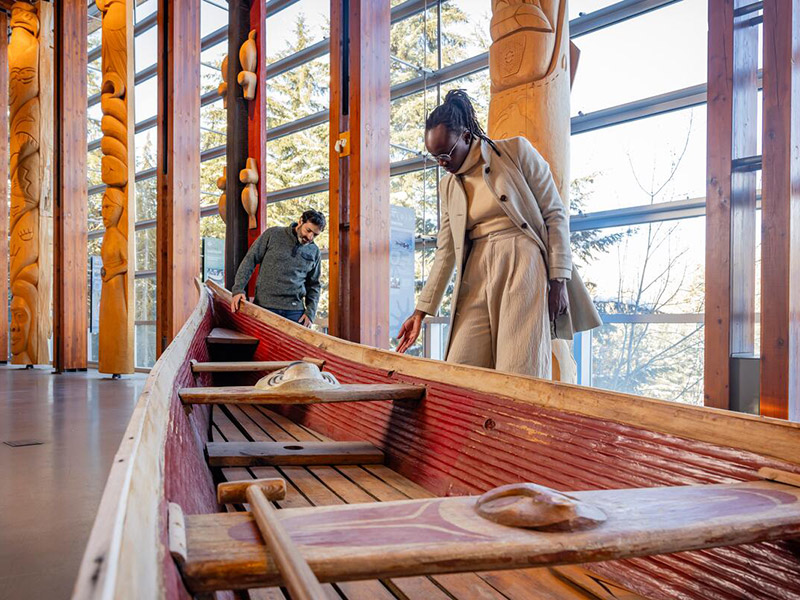 Two people taking a tour of Squamish Lil'wat Cultural Centre