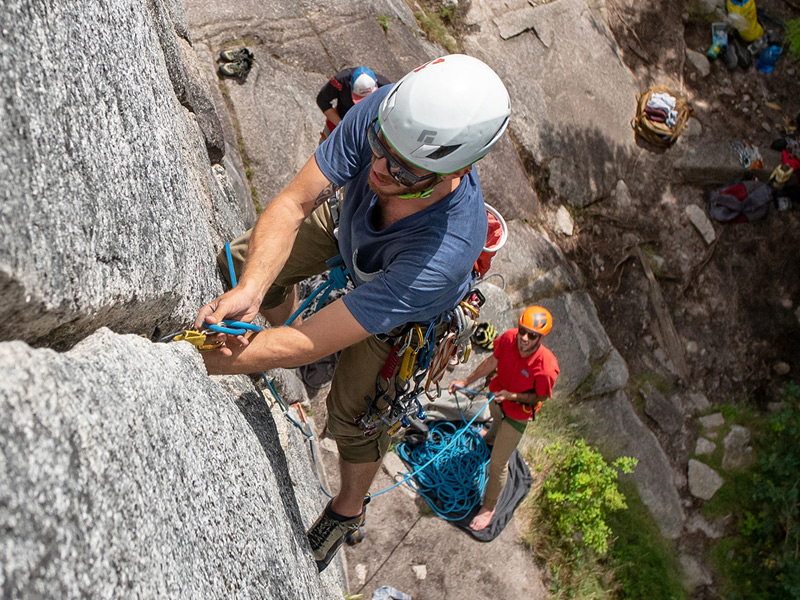Guided rock climbing in Whistler, BC, climber ascending a granite wall with ropes while partners belay below