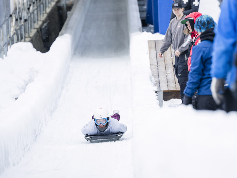 A participant rides a skeleton sled headfirst down the ice track at the Whistler Sliding Centre.