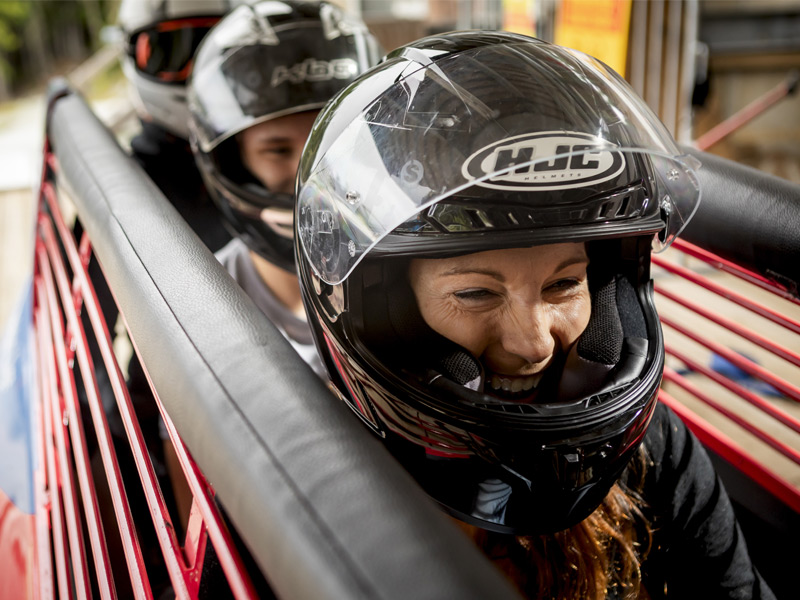 A summer bobsleigh carrying guests speeds down the Whistler Sliding Centre track with a trained pilot.