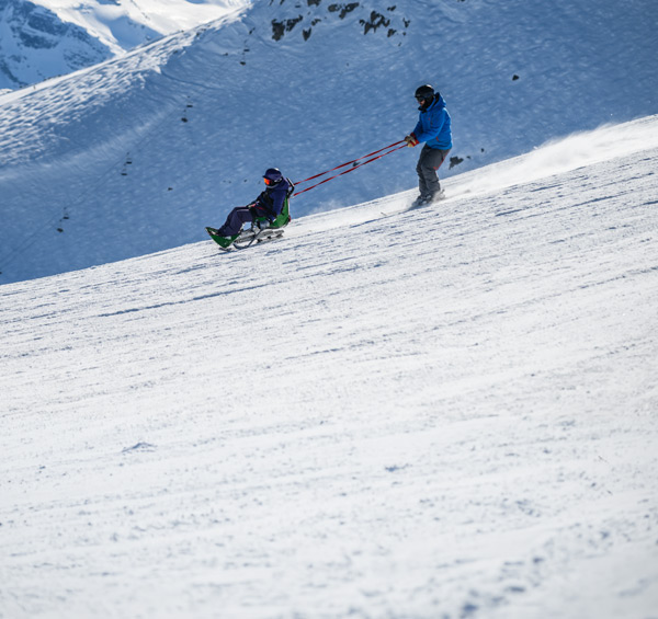 Whistler Adaptive assisting someone on a sit-ski