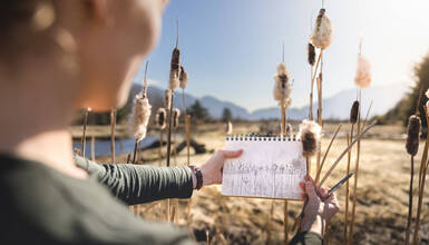 A person sketching while standing in a marshy area of Whistler in fall. The sketch closely mirrors the real nature in front of them.