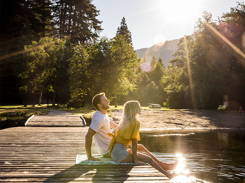 Two people sitting on a dock at a Whistler lake