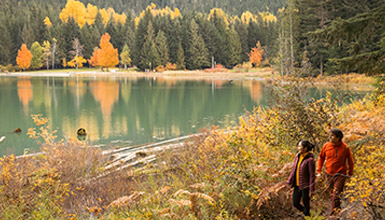Two people hiking around the lake in Autumn in Whistler