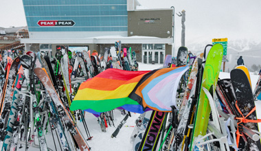 A Pride flag flies at the top of Whistler Mountain in the winter time.