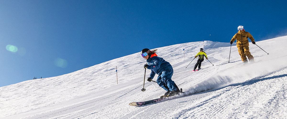 Three skiers hitting the Whistler slopes in the sun