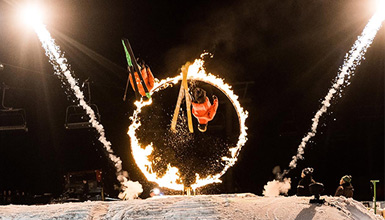 Two athletes jumping through fire on skis at Whistler's Fire & Ice Show