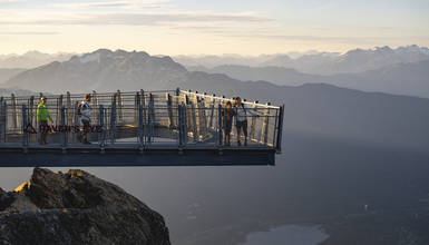 Visitors enjoying panoramic alpine views from the Raven’s Eye Lookout, perched off the Cloudraker Skybridge on Whistler Peak.
